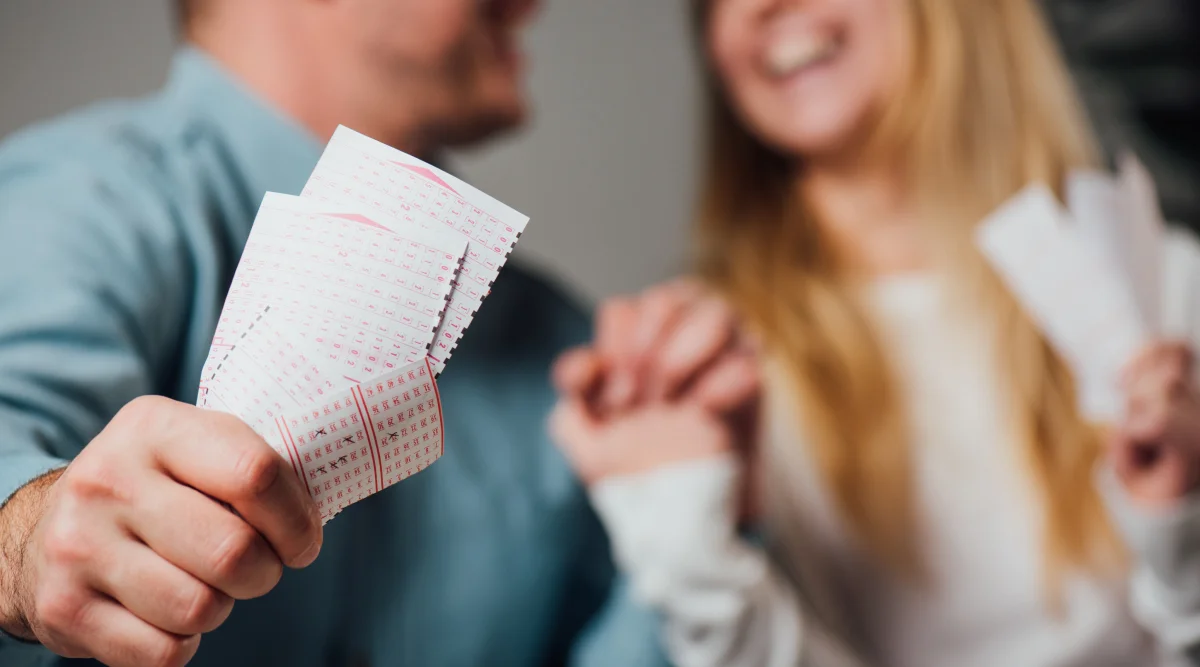 Man and woman test their luck with some lottery tickets 
